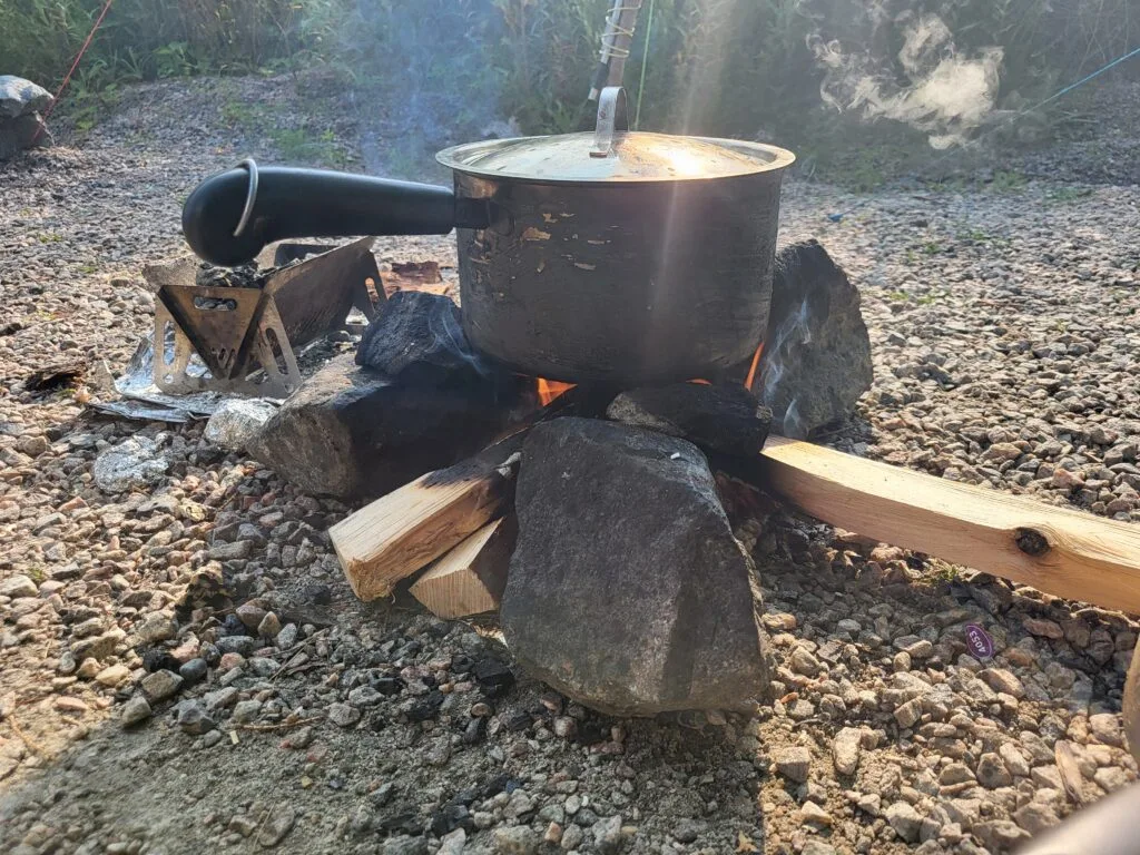 Sauce pan on stones - : Important Items you need for camping.