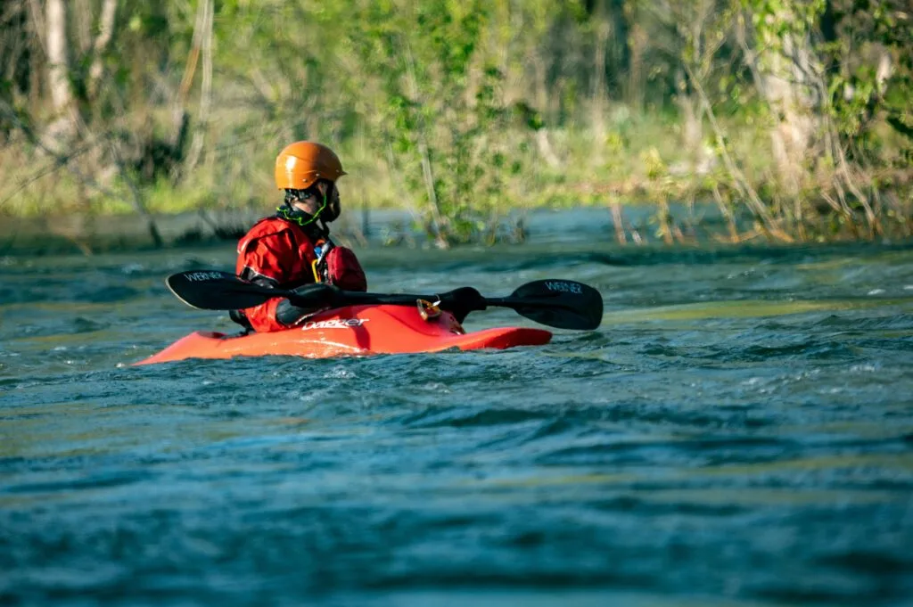 A man kayaking with a full safety gear
