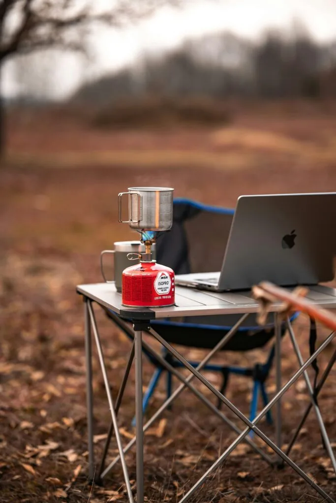 A table with PC and stove outdoor.